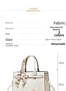 Detail view of cream fabric handbag with floral embroidery and printed silk scarf handle