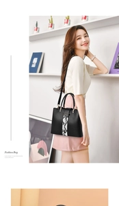 Fashionable black faux leather handbag with snakeskin pattern panel and gold hardware details