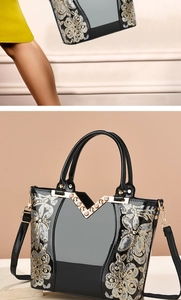 Detail der schwarzen Lackhandtasche mit Glitzermuster und Strasssteinen am V-Metallrand