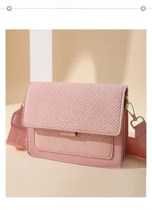 Detail of pink crossbody bag showing fine diagonal weave texture and gold metal hardware
