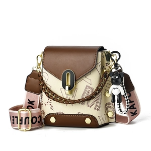 Sac bandoulière crème et marron avec imprimé lettres, chaîne et pendentif ours