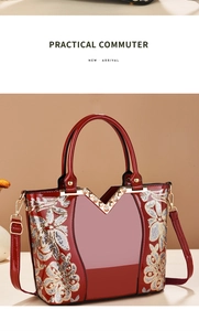 Detail der roten Lackledertasche mit goldener Blumenstickerei und metallischer V-Verzierung