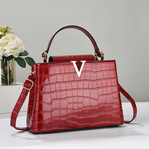 Borsa rossa motivo coccodrillo con logo V dorato e tracolla regolabile