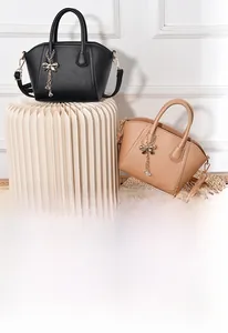 Detail of elegant lychee texture leather handbags with metal bow and tassel charms