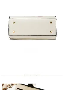 Bottom view of beige leather handbag featuring four protective gold metal feet and neat stitching