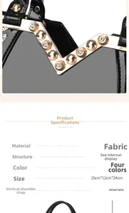 Detailansicht einer schwarzen Stoffhandtasche mit goldener V-Hardware und Nieten