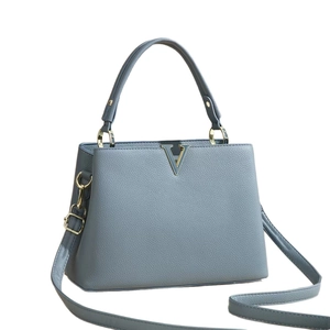 Elegant trapezoidal grey-blue leather handbag with gold V-clasp and top handle
