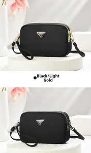 Detail view of black nylon crossbody bags with golden and gunmetal hardware accents