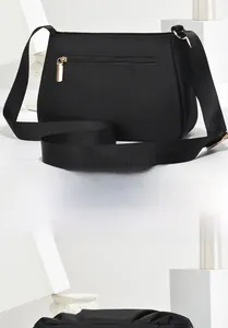 Detail of black nylon shoulder bag showing the back zipper pocket and pleated top design