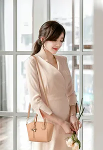 Detail of apricot shell bag with lychee texture and metallic bow charm in warm lighting