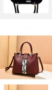 Detail of dark red leather handbag with snakeskin pattern and internal divider