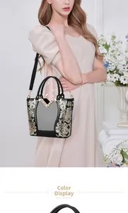 Detail einer schwarzen Vintage-Handtasche mit goldener Blumenstickerei und V-Metall-Dekor