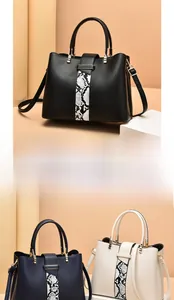 Detailed view of large capacity tote bag with snake pattern patch and gold hardware