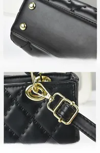 Detail of black quilted leather handbag showing gold protective feet and strap buckles