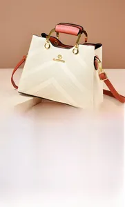 Close-up of beige tote bag featuring V-shaped embossed texture and gold hardware details