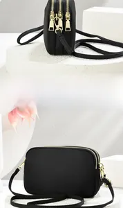 Detailed side and front view of a black nylon crossbody bag with three zipper compartments