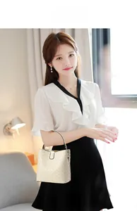 Chic cream woven leather bucket bag styled with a professional white ruffled blouse