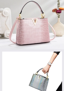 Detail of elegant crocodile-embossed handbag with gold V-hardware and top handle