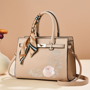 Elegant beige pink handbag with floral embroidery and silk scarf handle decoration