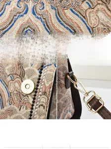 Dettaglio del tessuto jacquard vintage, fibbia magnetica dorata e tracolla in pelle marrone con gancio
