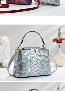 Detailed view of crocodile pattern patent leather handbag with gradient finish and gold V-buckle