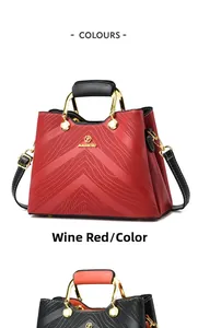 Close-up of wave textured handbags in wine red and black with golden metal hardware