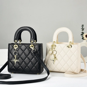Elegant quilted handbags in black and cream featuring gold hardware and star pendants