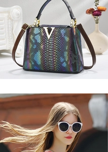 Macro detail of glossy crocodile texture and gold V buckle on elegant handbag