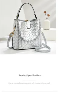 Detail of silver metallic woven bucket bag with top handle and adjustable shoulder strap