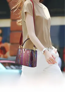 Detail of the holographic crocodile pattern leather and golden V-shaped buckle on handbag