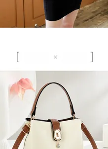 Dettaglio borsa crema con tracolla marrone, logo orso dorato e ciondolo elegante