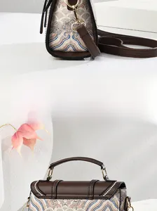 Dettaglio borsa ricamata vintage con manico in pelle e ganci metallici dorati