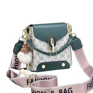 Green vintage mini crossbody bag with floral pattern, wide strap and plush pendant