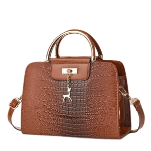 Brown crocodile pattern handbag with metal ring handle and gold deer charm detail