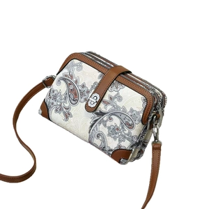 Retro paisley print mini crossbody bag with three zippers and brown leather trim