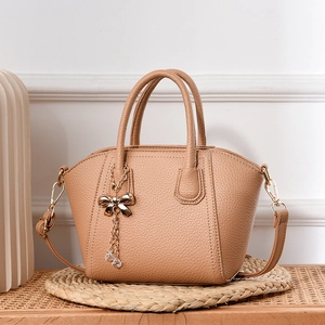Chic shell-shaped crossbody bag in beige leather with bow tassel and top handles