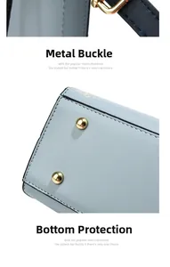 Détail d'un sac en cuir bleu clair montrant les boucles dorées et les clous de fond en métal