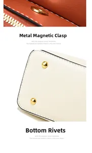Detail of magnetic hardware closure and protective golden rivets on beige leather bag