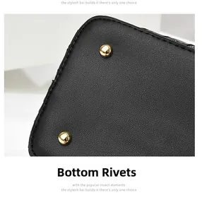 Detail of protective gold metal rivets on a black pebbled leather handbag bottom