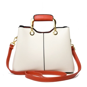 Elegant white and orange patchwork handbag with gold hardware and shoulder strap