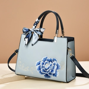 Sac à main bleu clair avec broderie florale et détail de foulard en soie