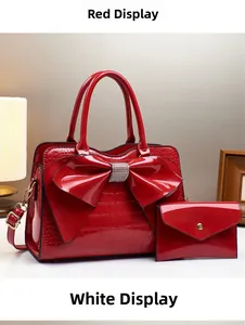 Detail der roten Handtasche aus Lackleder mit Krokodilmuster und glitzernder Strass-Schleife