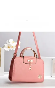 Detail of pink patent leather handbag with diamond stitching and gold deer charm