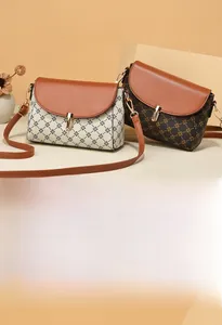 Detail of vintage monogram crossbody bags with golden metal clasps and leather straps