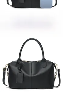 Detailed size comparison of the black leather Boston bag next to a smartphone device
