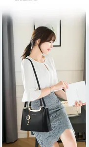 Black lychee leather handbag with gold handle and star pearl charm shown on model