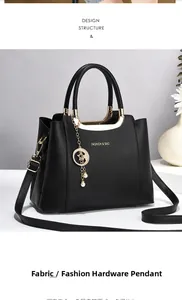 Detail of black lychee leather handbag with gold star-moon pendant and slim strap