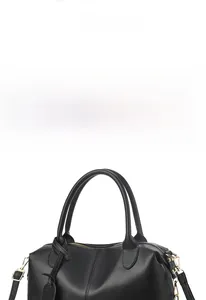 Detailed view of black litchi pattern leather handbag with gold hardware and round handles