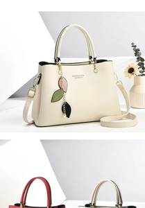 Detail of off-white lychee texture bag with clover charm and gold hardware