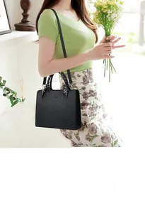 Détail du sac cabas noir à texture litchi avec foulard élégant enroulé sur la poignée